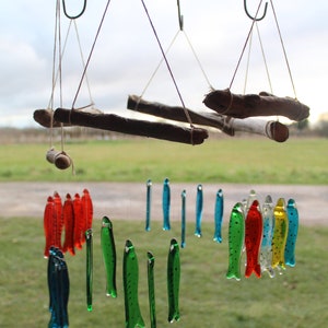 fish wind chimes hanging from driftwood. Fishes made in fused glass and make a lovely wind chime. image 10