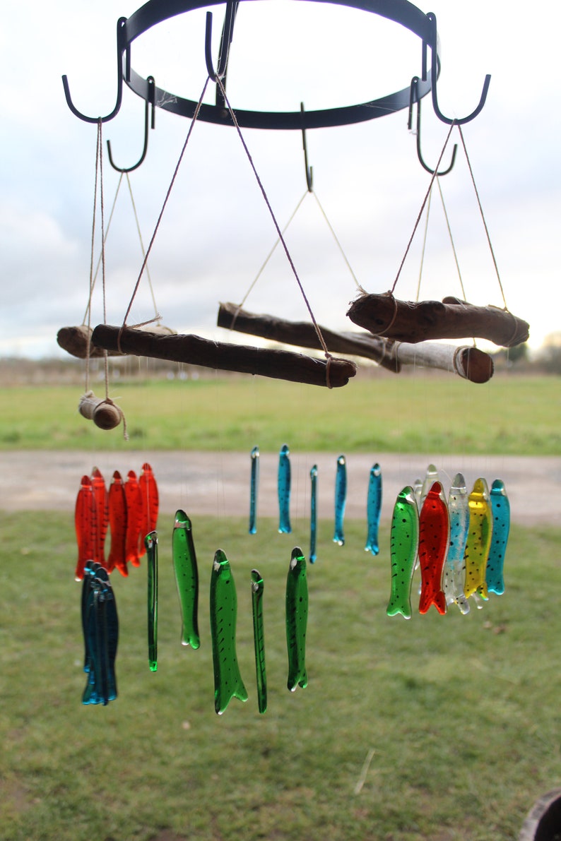 fish wind chimes hanging from driftwood. Fishes made in fused glass and make a lovely wind chime. image 10