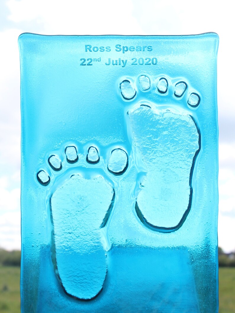 Puede incluir: Una placa de vidrio azul claro con la inscripci&oacute;n "Ross Spears 22nd July 2020" y dos huellas de manos claras.