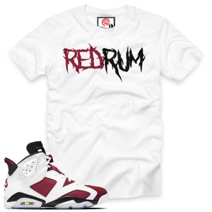 May include: White t-shirt with "RED RUM" printed in black and burgundy lettering.  Burgundy and white sneakers with black accents.