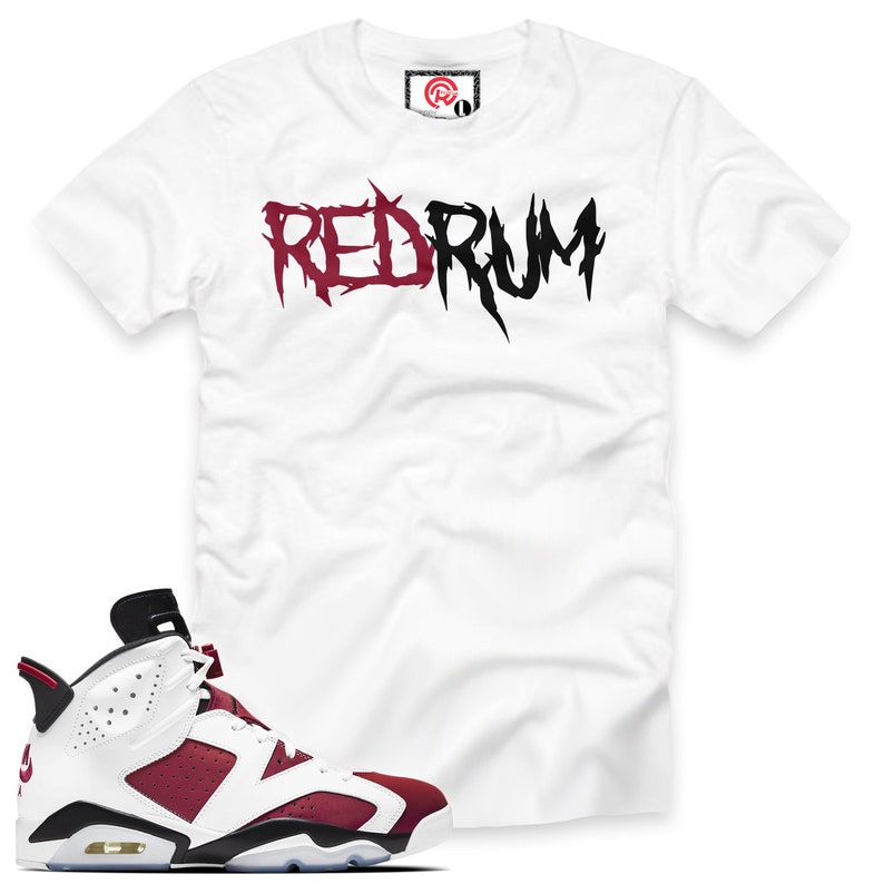 May include: White t-shirt with "RED RUM" printed in black and burgundy lettering.  Burgundy and white sneakers with black accents.