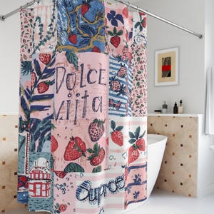 Puede incluir: Una cortina de ducha de patchwork con temática de fresas. La cortina presenta paneles rosas, azules y blancos con ilustraciones de fresas y las palabras "Dolce Vita" y "Surpre". El diseño incluye patrones florales y a rayas.