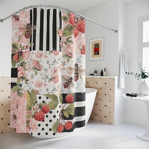 Könnte beinhalten: Ein Patchwork-Duschvorhang mit Blumen- und Bienenmuster. Der Vorhang hat abwechselnde Bahnen aus schwarz-weißen Streifen, Tupfen und Blumenmustern mit rosa Rosen, Himbeeren und Bienen. Der Vorhang hängt in einem Badezimmer.