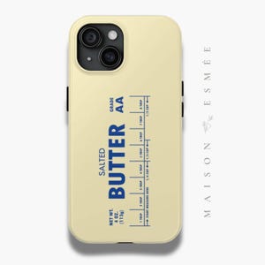 May include: A yellow phone case with a blue and white label that reads "SALTED BUTTER AA" and includes a measurement guide for tablespoons and cups. The label also includes the text "NET WT. 4 OZ. (113g)".