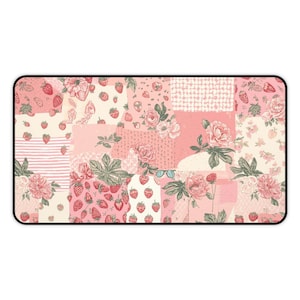 May include: Rectangular mouse mat with a patchwork design. The design features pink and white floral and strawberry patterns, including roses, strawberries, and butterflies. It has a black border.