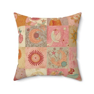 Peut inclure: Coussin carré avec un motif patchwork. Le design présente des motifs floraux, célestes et géométriques dans des tons de rose, orange et crème. Le coussin a un aspect doux et texturé, idéal pour ajouter une touche bohème à n'importe quelle pièce.