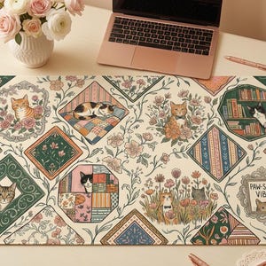 Puede incluir: Alfombrilla de escritorio decorativa con un diseño temático de gatos. La alfombrilla presenta ilustraciones de gatos en marcos ornamentados y patrones florales, con el texto "PAW-SITIVE VIBES". La paleta de colores incluye crema, verde y tonos pastel.