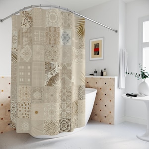 May include: A beige and brown patchwork shower curtain with a variety of patterns, including floral, geometric, and leaf designs. The curtain is hanging from a curved, silver-colored shower rod. The bathroom has a white tub and walls.