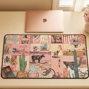 Pode incluir: Tapete de mesa retangular com tema do sudoeste, com cactos, vacas e paisagens desérticas em um design de patchwork. O tapete é predominantemente rosa e bege, com uma borda preta. Um laptop está em cima.