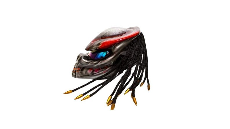 Pu&ograve; includere: Un casco da moto con un design Predator. Il casco presenta una combinazione di colori rosso e argento, con dreadlocks neri e punte dorate. La visiera &egrave; blu e il casco ha un aspetto dettagliato e strutturato.