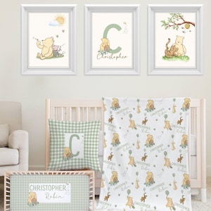 Puede incluir: Un juego de guardería con impresiones artísticas enmarcadas, una almohada, una manta y una caja de almacenamiento. Las impresiones representan a los personajes de Winnie the Pooh. La almohada y la caja tienen un patrón de cuadros verdes. La manta tiene un patrón repetido de Pooh y amigos con el nombre "Christopher Robin".