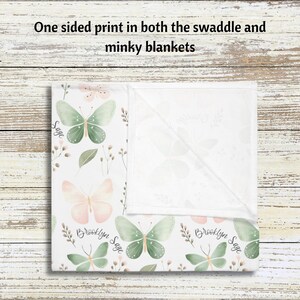 May include: A white swaddle blanket with a green and pink butterfly pattern. The blanket has the names "Brooklyn Sage" printed on it.