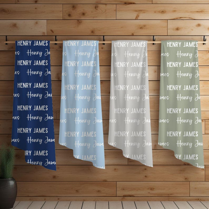May include: Four personalized blankets with the name "Henry James" repeated in white text on a blue, light blue, gray, and green background.