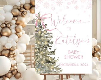 May include: A pink and white welcome sign with a watercolor illustration of a Christmas tree with lights. The sign reads "Welcome to Katelyn's Baby Shower December 6, 2024".