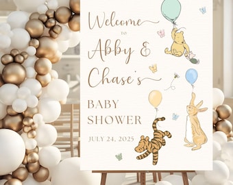 Puede incluir: Un letrero de bienvenida para baby shower sobre un caballete, con personajes de Winnie the Pooh y globos. El letrero dice "Bienvenida a la baby shower de Abby & Chase, 24 de julio de 2025". El fondo incluye un arco de globos blancos y dorados.