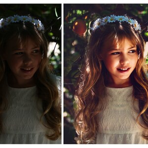 May include: A young girl with long brown hair wears a white dress and a flower crown. She is smiling and looking to the side. The background is a blurred image of green leaves and a bright orange fruit.