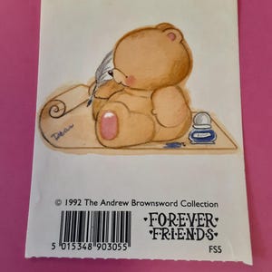 May include: A Forever Friends card featuring a light brown teddy bear writing with a quill on a scroll. The bear sits on a wooden surface with an inkwell. The card has the text "Forever Friends" and the copyright information.