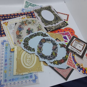 May include: A collection of colorful paper craft frames and borders, including floral wreaths, geometric patterns, and a Mickey Mouse design. The frames are perfect for scrapbooking, card making, and other paper crafts.
