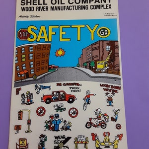 以下が含まれることがあります： 子供向けの安全ステッカーシート。建物、車、自転車、建設クレーン、停止標識など、漫画の街のシーンが描かれています。ステッカーには、「注意して、先に考えよう！」や「シートベルトを着用しよう！」などの安全メッセージが書かれています。