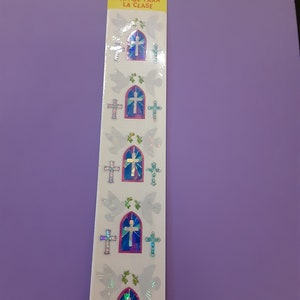 May include: A sheet of stickers with a white background and iridescent images of stained glass windows with crosses and doves. The text "CLASSPAK ENVASE PARA LA CLASE" is printed on the sheet.