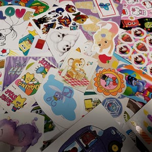 Puede incluir: Una colorida variedad de pegatinas vintage con personajes de dibujos animados, animales y varios diseños. Incluye a Snoopy con globos, una sirena, fresas y otras ilustraciones lúdicas. Una colección nostálgica de pegatinas decorativas.