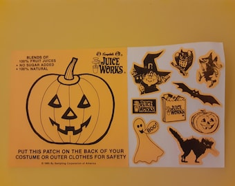 Könnte beinhalten: Ein Bogen mit orangefarbenen und schwarzen Halloween-Aufklebern mit einem Kürbis, einer Hexe, einem Geist, einer Katze, einer Fledermaus und einem Saftkarton. Die Aufkleber sind von Campbell's Juice Works und es steht "Klebe diesen Patch auf die Rückseite deines Kostüms oder deiner äußeren Kleidung, um sicher zu sein."