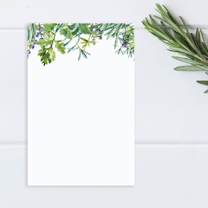 May include: A white rectangular card with a watercolor illustration of various herbs and small purple flowers along the top edge. A sprig of fresh rosemary is on the right side, against a white wooden background.