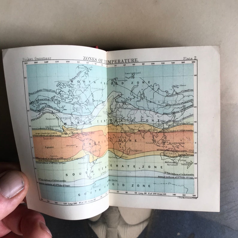 Op de afbeelding: Een vintage kaart die de temperatuurzones over de hele wereld illustreert. De kaart is verdeeld in vijf zones: koud, gematigd, tropisch, noordpoolgebied en zuidpoolgebied. De kaart is afgedrukt op een pagina uit een boek getiteld "Pocket Gazetteer".