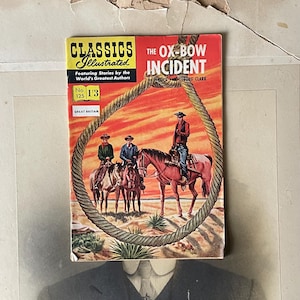 May include: A vintage copy of "The Ox-Bow Incident" comic book by Walter Van Tilburg Clark. The cover depicts cowboys on horseback in a Western setting, encircled by a rope. It's from the "Classics Illustrated" series, No. 125, published in Great Britain.