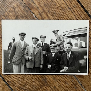Cartão postal antigo com retrato real - Homens de boné - Festa na carruagem, década de 1930 - Busy Bee Coaches - Caernarfon - País de Gales