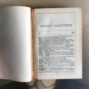Op de afbeelding: Een pagina uit een vintage zakgazetteer met een lijst van locaties en hun beschrijvingen. De pagina is open naar de letter "A" en bevat vermeldingen voor plaatsen zoals Aach, Aken, Aadorf, Aafiord, Aagaard, Aakirkeby, Aal, Aalborg, Aalbuch, Aalen, Aalesund, Aalsmeer, Aalst, Aalten, Aalum, Aamodt of Aamadt, Aar, Aarau, Aarberg, Aarburg, Aardenburg, Aared of Arid, Aargau, Aarhus, Aarlanderveen, Aarle-Rixtel, Aarm&uuml;hle, Aaroe.