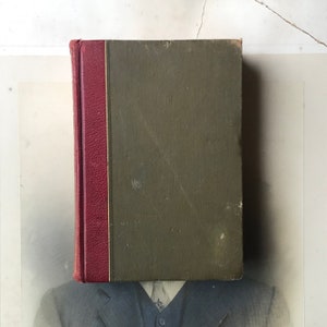 Può includere: Un libro vintage rilegato con una copertina verde scuro e una costa rossa.