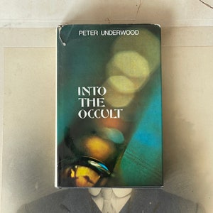 Puede incluir: Una portada de libro con fondo verde y azul. El título "Into The Occult" está impreso en letras blancas. El nombre del autor, "Peter Underwood", está impreso en letras blancas en la parte superior de la portada.