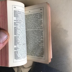 Op de afbeelding: Een open boek met een vergeelde pagina waarop een lijst met geografische locaties en hun bijbehorende beschrijvingen staat. Het boek is gebonden in bruin leer met gouden letters op de rug. De pagina is open op de letter "G" en bevat vermeldingen voor plaatsen zoals Gibraltar, Giarret, Giaveno en Giarre Ripostola.
