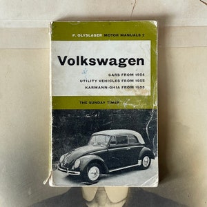 May include: A vintage green and black book titled "Volkswagen" with the text "Cars from 1954, Utility Vehicles from 1955, Karmann-Ghia from 1955, The Sunday Times" on the cover. The book features a black and white photo of a Volkswagen Beetle convertible.