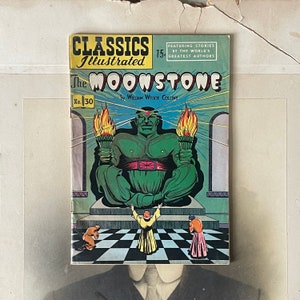 May include: A vintage comic book titled "The Moonstone" by William Wilkie Collins. The cover features a green figure holding torches, with the text "Classics Illustrated" and the price "15¢". The comic is No. 30.