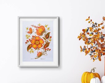 May include: Framed floral artwork with a bright orange and yellow flower design, a butterfly, and leaves. The artwork is in a white frame. The image also includes a vase of orange branches and decorative pumpkins.