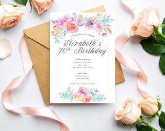 May include: A white invitation card with floral watercolor accents announces Elizabeth's 70th birthday garden party. The card is surrounded by peach roses, a brown envelope, and a pink ribbon.