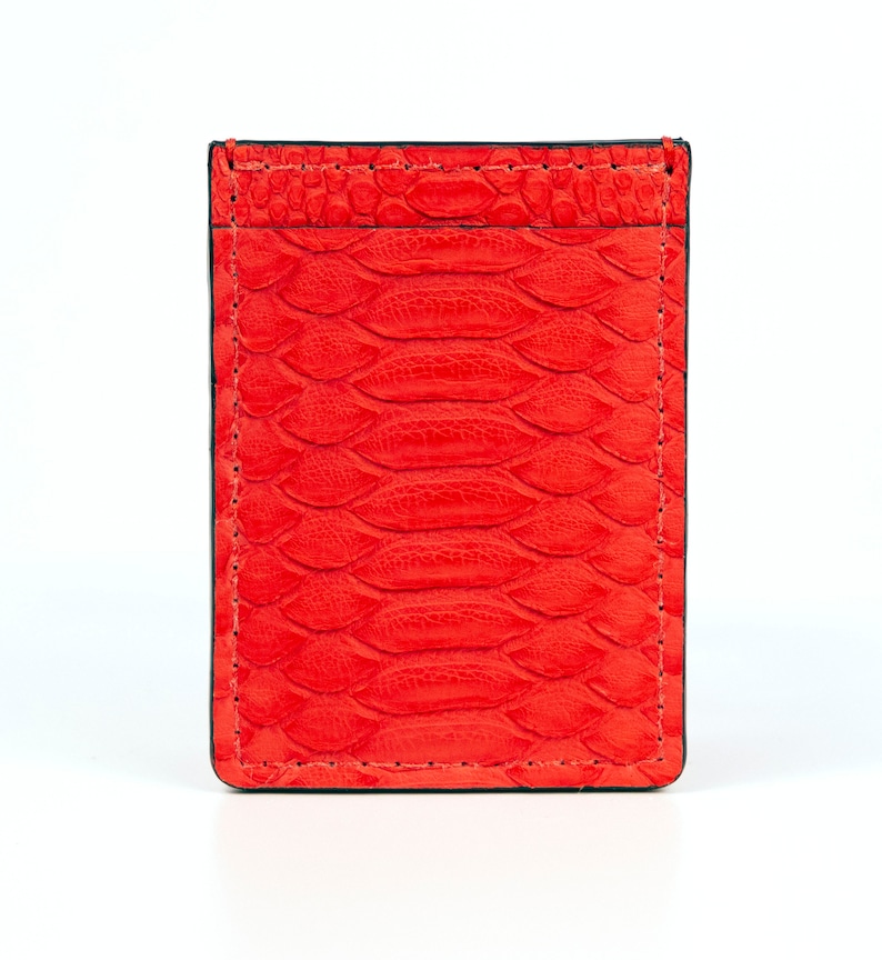 Puede incluir: Un porta tarjetas de cuero rojo con un patr&oacute;n de piel de serpiente.