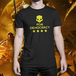 May include: Black t-shirt with a yellow skull and the text "FOR DEMOCRACY" with five yellow stars.