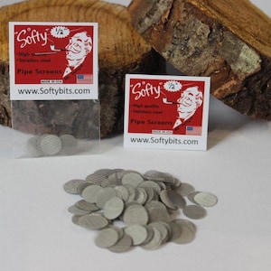 May include: A package of small, round, silver pipe screens with the brand name "Softy" printed on the packaging. The packaging is red with white text and a cartoon image of a man smoking a pipe. The text on the packaging reads "High quality stainless steel pipe screens made in the USA. www.Softybits.com"