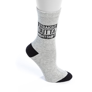 May include: Gray crew socks with a black heel and toe. The socks have a black rectangle with the text "STRAIGHT OUTTA NIGHTSHIFT" printed on them.