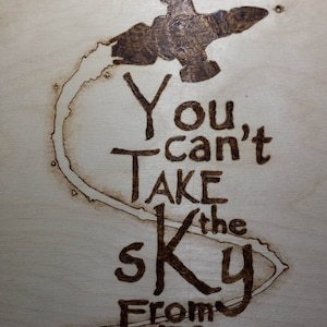 Może przedstawiać: Drewniany znak wypalony z kosmicznym statkiem i tekstem "You can't take the sky from me".