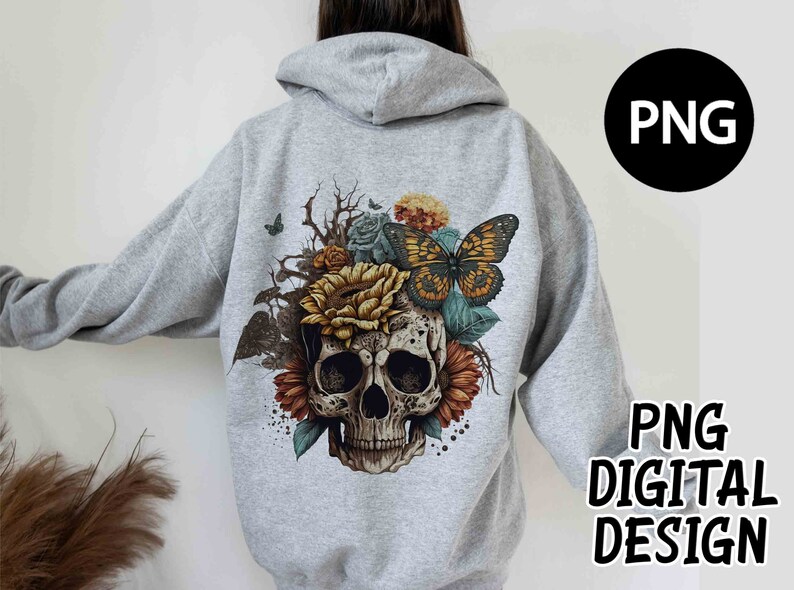 May include: A light gray hoodie featuring a detailed graphic of a skull adorned with sunflowers, roses, and a butterfly. The design includes the text "PNG DIGITAL DESIGN" in black. The hoodie has a hood and long sleeves.