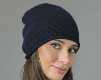 May include: A dark blue knitted beanie hat. The hat is slouchy and has a simple design.