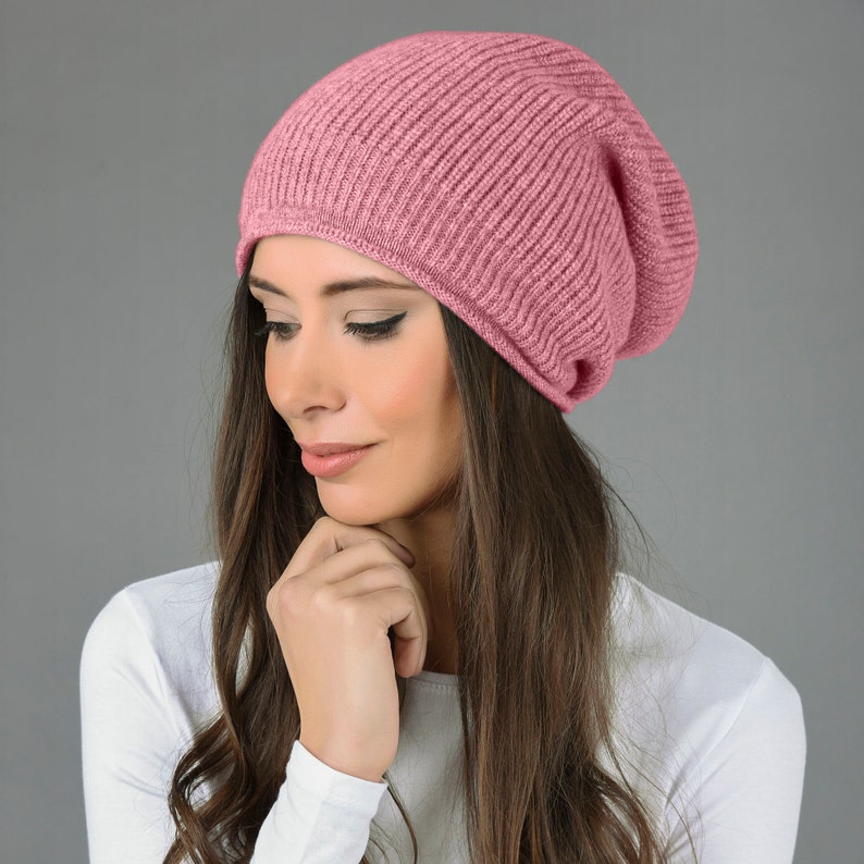 May include: A pink slouchy beanie hat made of soft knit fabric. The hat is folded down at the brim and has a relaxed, casual look.