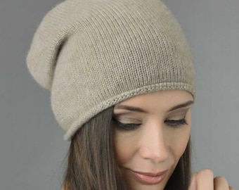 May include: A beige slouchy beanie hat made of soft knit fabric.