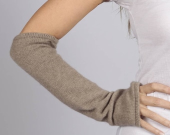 May include: A pair of brown cashmere arm warmers. The arm warmers are made of a soft, knitted fabric and extend to the elbow.