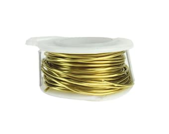 Pode incluir: Um carretel de fio dourado em um dispensador de plástico branco.