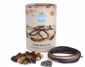 May include: A Pipkits Surfer Bands Kit in a cylindrical cardboard tube featuring a graphic of finished bracelets. The kit includes a pile of assorted brown and tan wooden beads, a small cluster of metallic beads, and coiled lengths of cord.